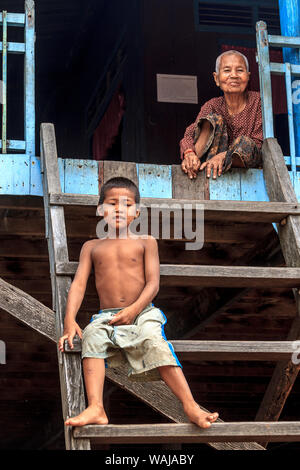 Kompong Pluk (Phluk), Cambodia. Young boy and his grandmother at their house. This is a cluster of three villages made of stilt houses within the floodplain of the Tonle Sap Rive. (Editorial Use Only) Stock Photo