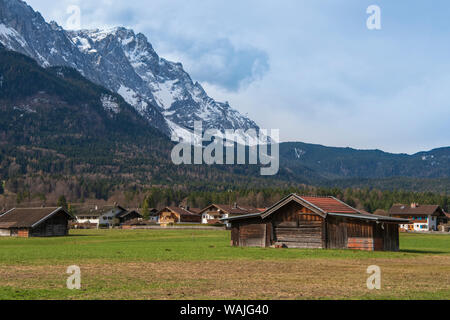 Zugspitze in the backdrop of farming huts on a field in the village of Grainau, Bavaria Stock Photo