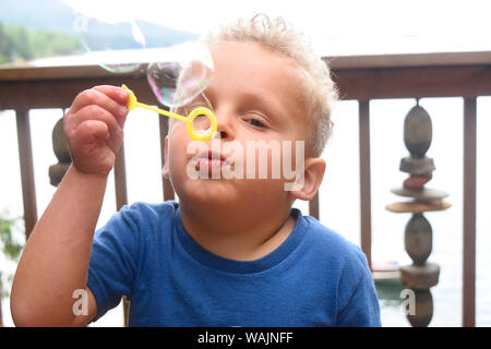 3 year old boy blowing bubbles. (MR) Stock Photo