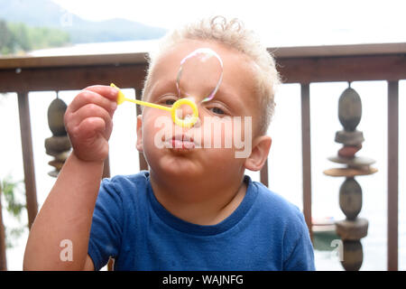 3 year old boy blowing bubbles. (MR) Stock Photo