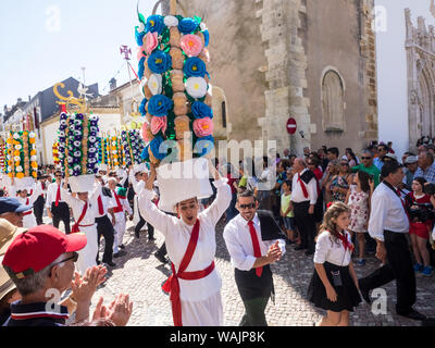 Portugal, Tomar. Girls carrying the Tabuleiros in the procession are decorated with symbols of the Holy Spirit Stock Photo