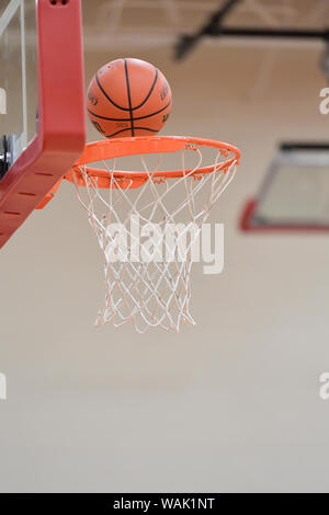 Basketball going through hoop. Stock Photo