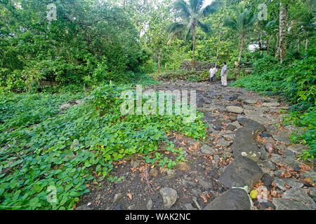 Kosrae, Micronesia (FSM). Local Kosrae men talking at Lelu Ruins. The ruins, dating back to the 1400s and possibly earlier, were once the home of Kosrae royalty and include basalt walls, burial pits and ceremonial areas. (Editorial Use Only) Stock Photo