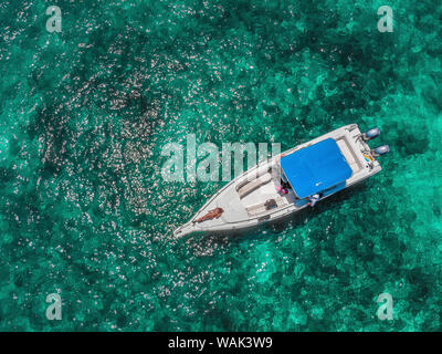 Colombia, Bolivar, Cartagena, Rosario Islands. Aerial view of young woman sunbathing on boat in Caribbean waters. (MR) Stock Photo