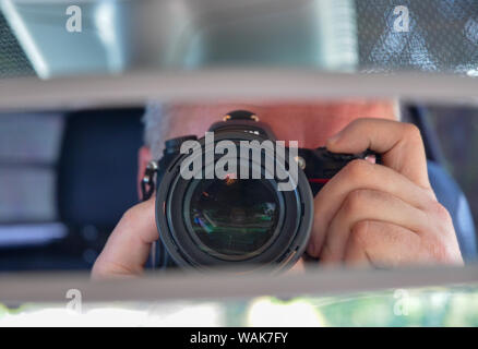 Photographer reflection in car rear view mirror Stock Photo