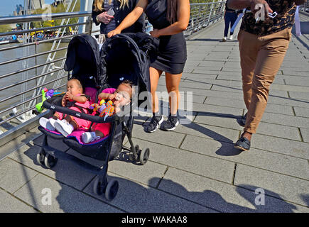 London, England, UK. Twins in a pushchair / buggy on the Millennium Bridge Stock Photo