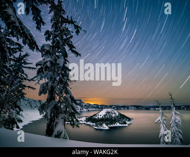 USA, Oregon, Crater Lake National Park. Star trails over Crater Lake and Wizard Island in winter. Stock Photo
