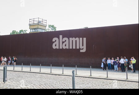 Berlin, Germany. 13th June, 2019. Many visitors come to the Berlin Wall Memorial on Bernauer Strasse every day. The watchtower rises above the rusty wall behind which the wall with the border strip, also called the death strip, is located. Credit: Annette Riedl/dpa-Zentralbild/ZB/dpa/Alamy Live News Stock Photo