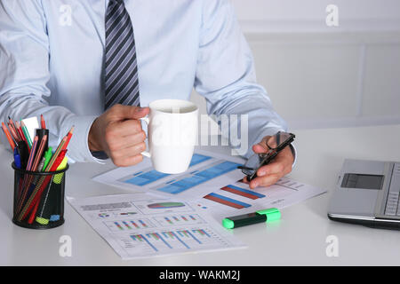 Handsome businessman having tea or coffee in office Stock Photo