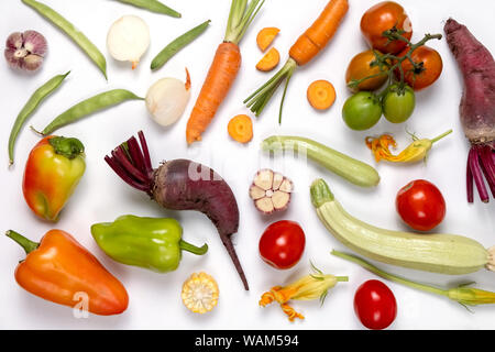 Pattern made of autumn vegetables. Food concept. Tomatoes, onion, cucumber, carrot, garlic, red beet, pepper, zucchini, maize and green haricot on whi Stock Photo