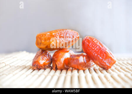 Group of Phoenix fruit on bamboo mat, dried fruits of date palm on bamboo mat background Stock Photo