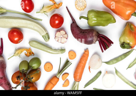Creative layout made of vegetables. Healthy eating concept. Tomatoes, onion, carrot, garlic, red beet, pepper, maize and green haricot on white backgr Stock Photo