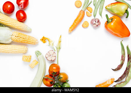Various fresh vegetables and herbs on over white background. Healthy eating concept. Tomatoes, onion, carrot, garlic, red beet, pepper, maize and gree Stock Photo