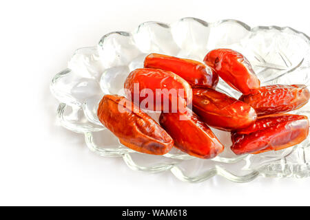 Dried fruits of date palm in glass bowl on white background, Phoenix dactylifera in glass bowl. Stock Photo