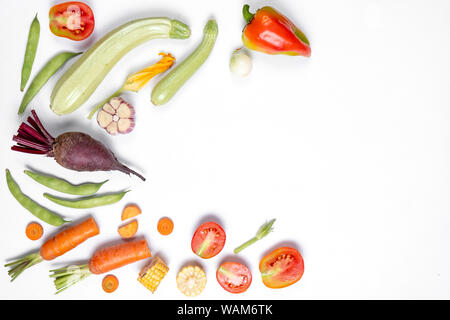 Pattern made of haricot, tomatoes, pepper, corn, onion, red beet, carrot, zucchinion white background . Flat lay, top view, copy space. Healthy eating Stock Photo