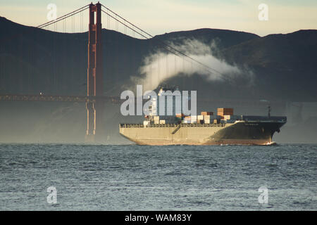 SAN FRANCISCO, CALIFORNIA, UNITED STATES - NOV 25th, 2018: A fast moving cargo container ship, entering San Francisco Bay, sailing underneath the Stock Photo