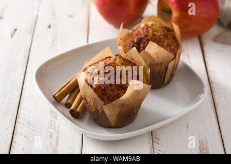 Apples and cinnamon muffins on white wooden table. Stock Photo