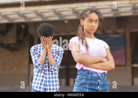 Teenagers having relationship difficulties. Girl sulking to her upset boyfriend Stock Photo