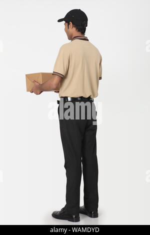 Rear view of a delivery man holding parcel Stock Photo