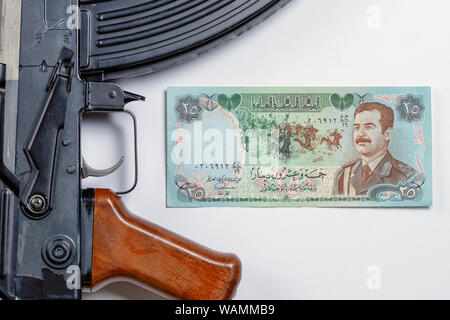 old Iraqi money depicting Saddam Hussein along with the Soviet AK 47