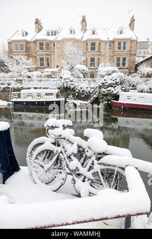 Bicycles covered in snow on a narrow boat moored on the Kennet and Avon Canal in Bath, England, UK. Stock Photo