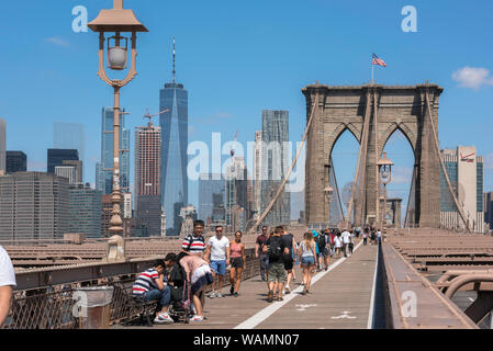 Brooklyn Bridge, view of people walking across Brooklyn Bridge on a summer day with the Lower Manhattan skyline in the background, New York City, USA Stock Photo