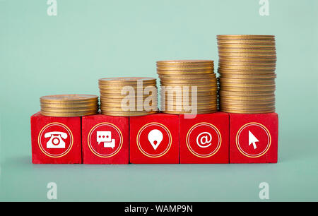 Contact us icon on wooden blocks with Coin Stack Stock Photo
