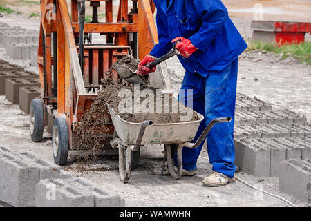 Construction worker pushing a wheelbarrow full of bricks isolated on ...