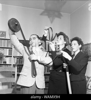 Film interest in the 1950s. A group of two women and a man are looking at what's on the film roll. Italy 1950. Kristoffersson Ref AY24-7. Sweden 1952 Stock Photo