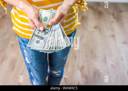 Young woman displays fanned out bills Stock Photo