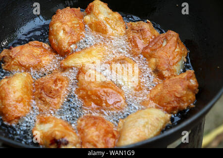 Fried chicken in a pan with hot oil. Golden yellow fried chicken in a pan. Stock Photo