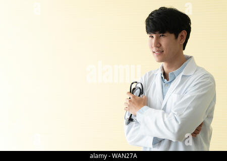 Portrait of Asian young doctor with arms crossed holding stethoscope in  hospital emergency lap. Concept of healthcare patient lifestyle and medical. Stock Photo