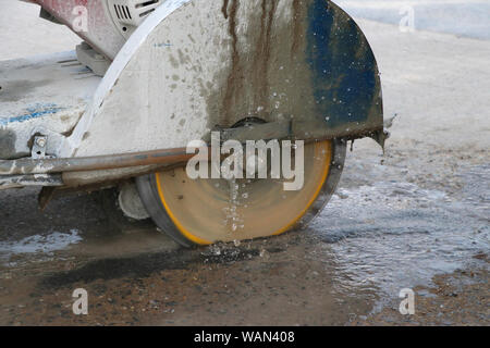 Concrete cutting machine are cutting concrete floor using cast water to reduce dust spread. Stock Photo