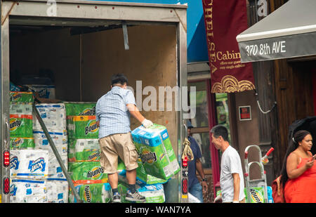 Workers unload paper products for a 99 cent store in the Chelsea neighborhood of New York on Friday, August 16, 2019.  (© Richard B. Levine) Stock Photo