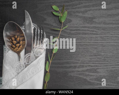 Traditional Christmas table place setting. Festive place setting for new year dinner. Beautiful cutlery cone branch on the white napkin and vintage Stock Photo