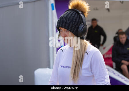 Jessica Hawkins wearing headphones and wooden hat in the paddock on race day. W Series last race of inaugural series 2019. Brands Hatch Stock Photo