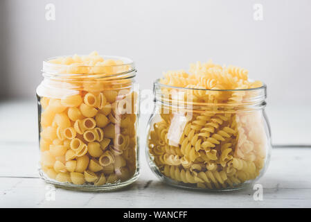 Two kinds of Italian whole wheat pasta in glass jars Stock Photo