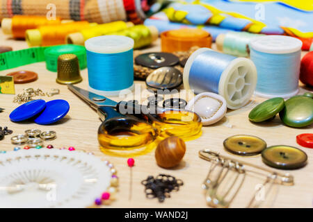 various accessories for sewing and needlework lie on the table close-up with blurred background and foreground Stock Photo