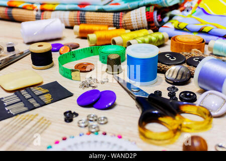 various accessories for sewing and needlework lie on the table close-up with blurred background and foreground Stock Photo