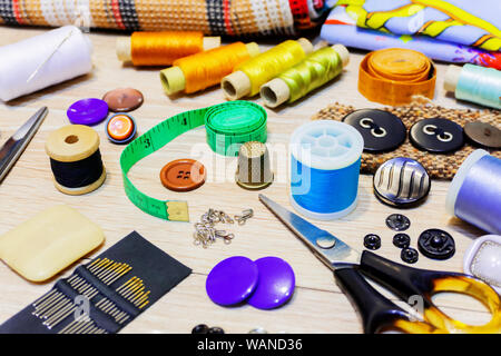 various accessories for sewing and needlework lie on the table close-up with blurred background and foreground Stock Photo