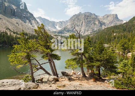 Hikers sit on the shore of The Loch, Rocky Mountain National Park, Colorado. Stock Photo