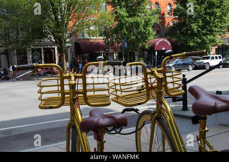 Saratoga Springs, New York State: August 4, 2019 - Two Golden Bicycles facing Broadway Street in front Adelphi Hotel, Downtown Saratoga Springs Stock Photo