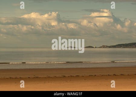 Low Billowing soft fluffy clouds over a low tide at Swansea beach, wales, U.K. Stock Photo