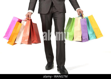 Low section of a businessman holding shopping bags Stock Photo