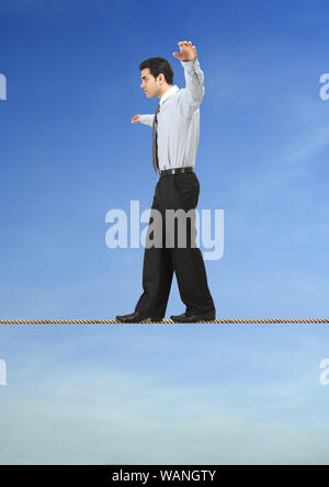 Businessman is balancing on a rope Stock Photo
