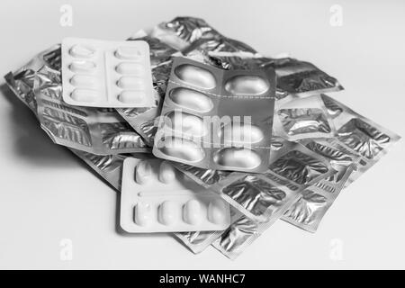 Blister packs of medicine tablets in a stack, on a plain background Stock Photo