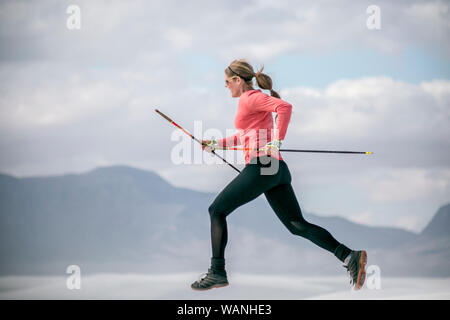 A woman runner glides across the terrain in White Sands, New Mexico Stock Photo