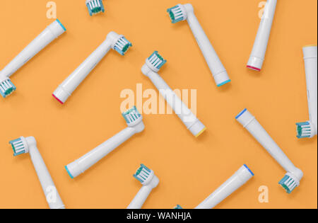 Pattern of electric toothbrush heads on an orange background Stock Photo
