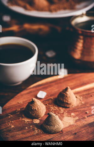 Homemade chocolate truffles coated in cocoa powder with black coffee Stock Photo
