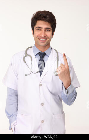 Male doctor showing vote sign Stock Photo